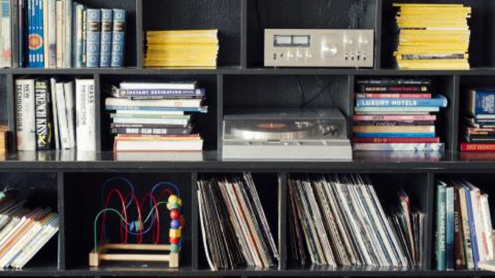 Scaffale nero con libri, riviste e dischi in vinile