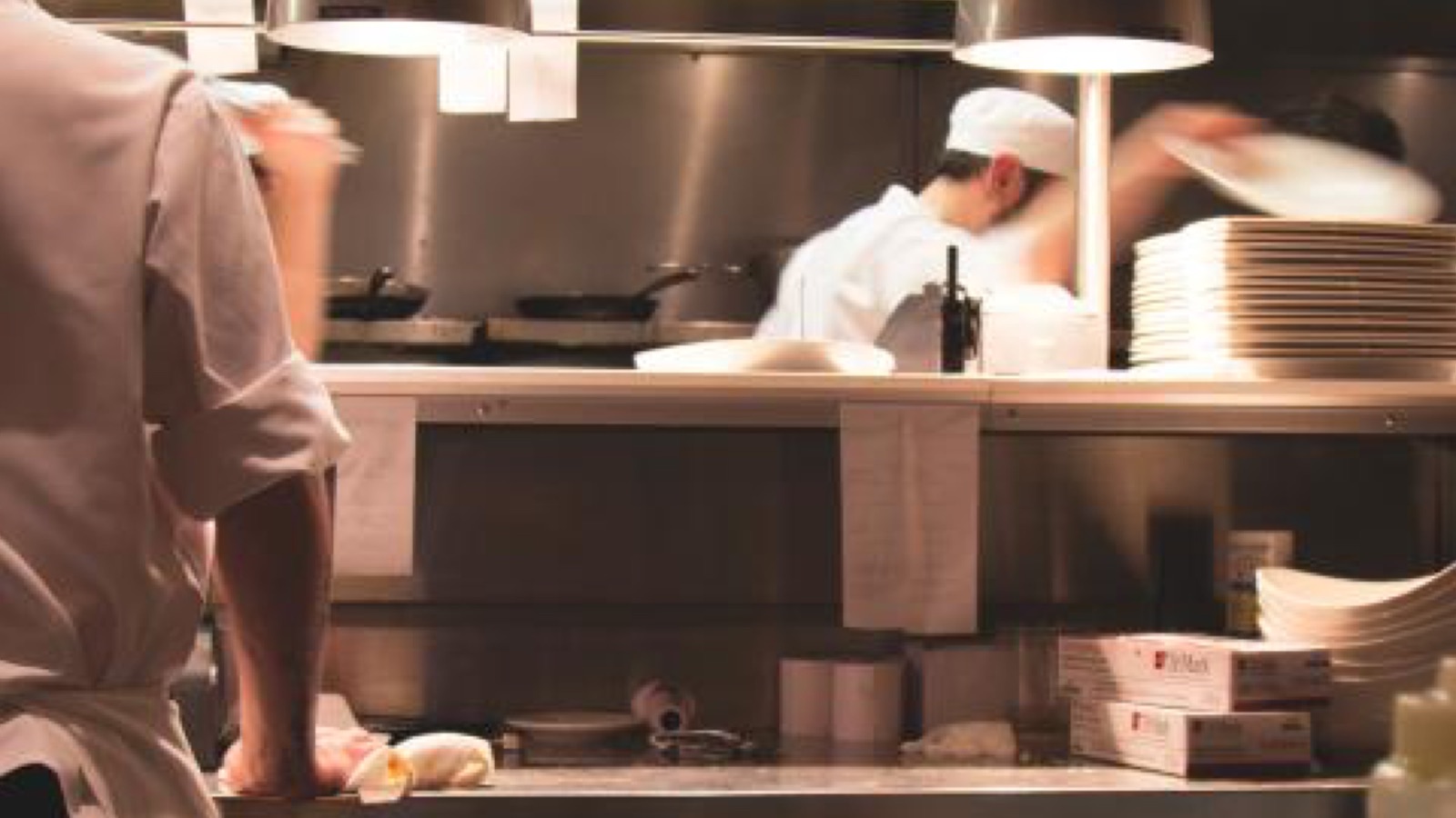 Cuochi al lavoro nella cucina di un ristorante durante il servizio