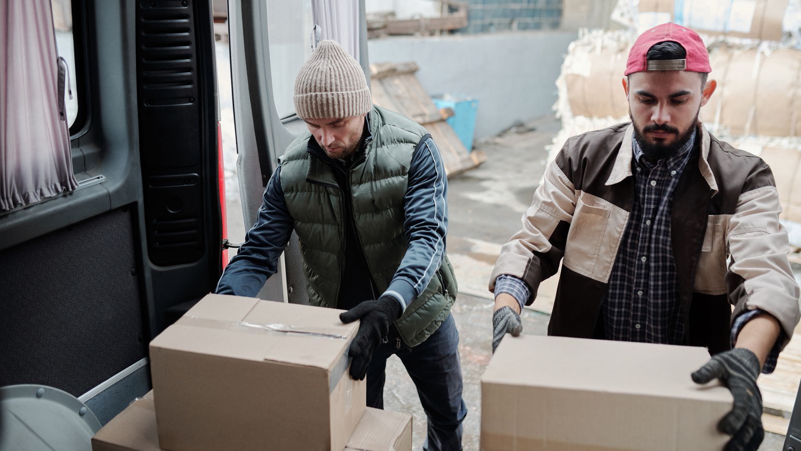 Lavoratori che caricano pacchi su un furgone